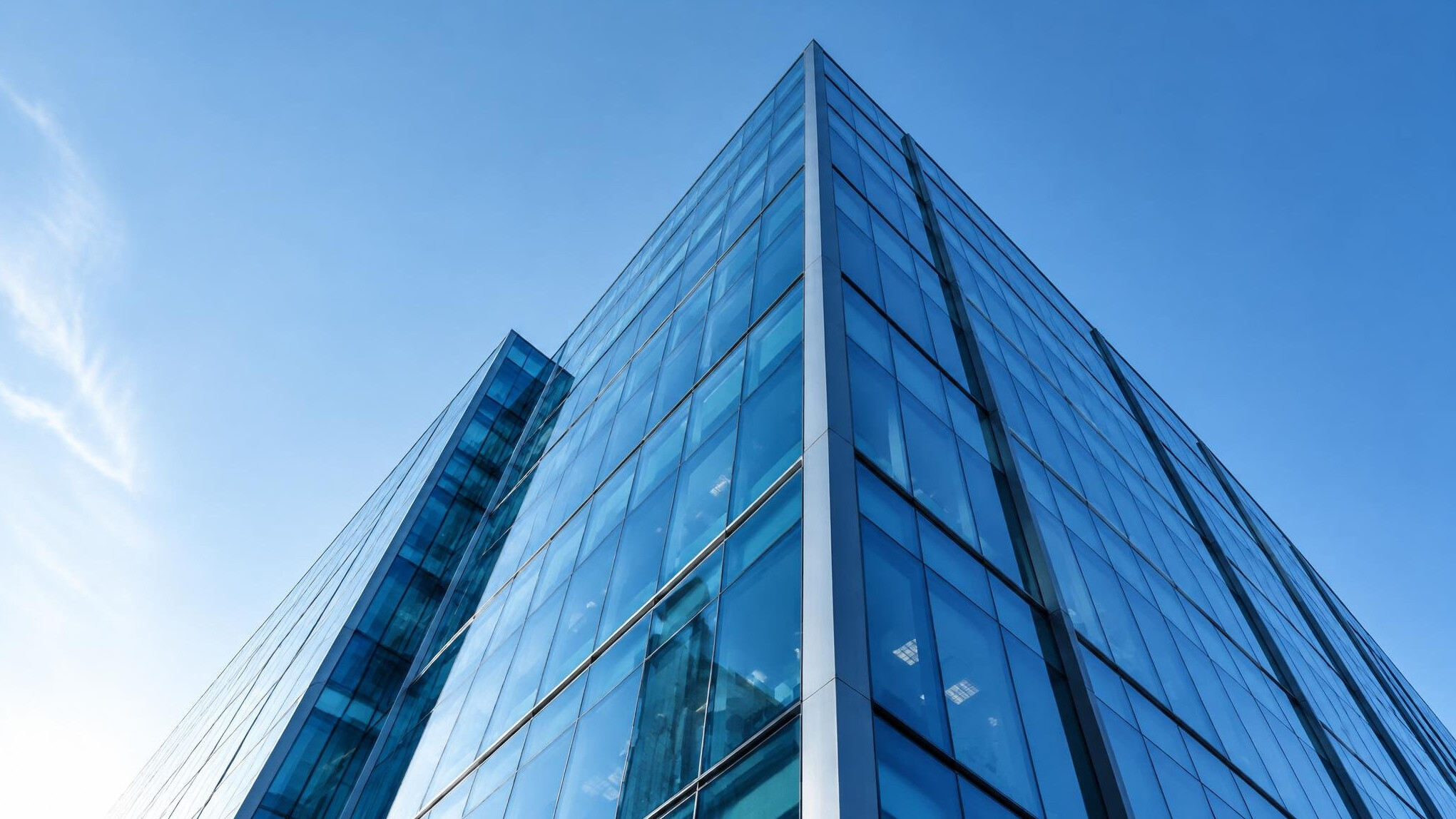 Modern office building with glass facade seen from below